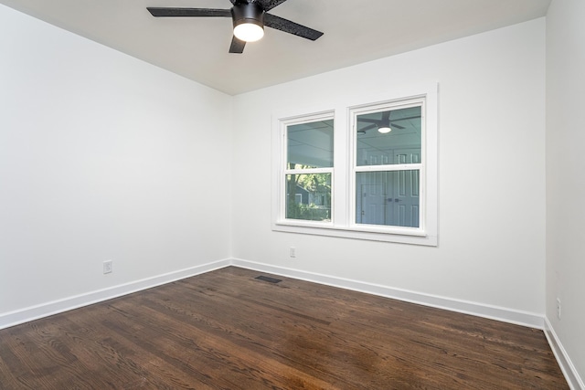 empty room with baseboards, visible vents, dark wood finished floors, and a ceiling fan