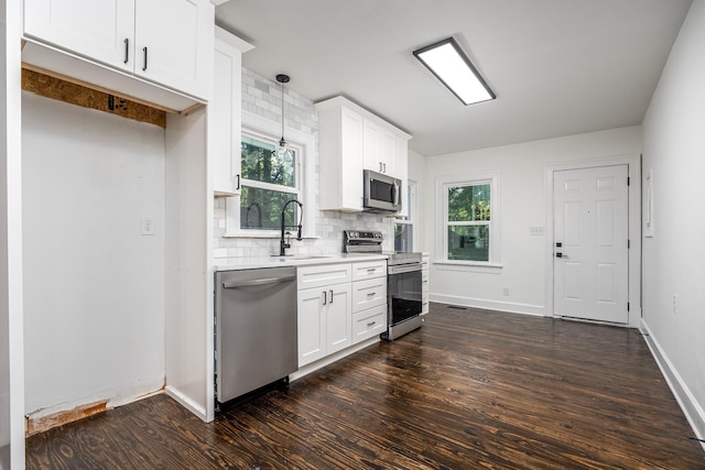 kitchen featuring stainless steel appliances, a sink, light countertops, decorative backsplash, and dark wood finished floors