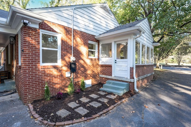 doorway to property with brick siding