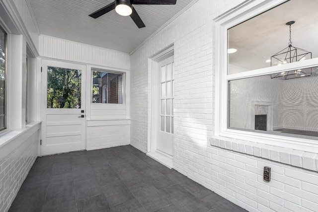 unfurnished sunroom with ceiling fan with notable chandelier