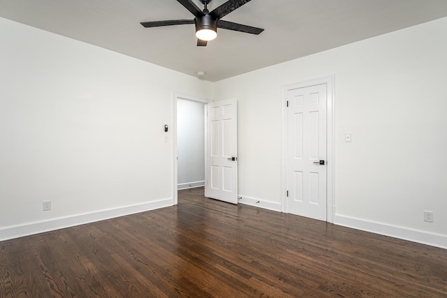 unfurnished room featuring a ceiling fan, dark wood finished floors, and baseboards