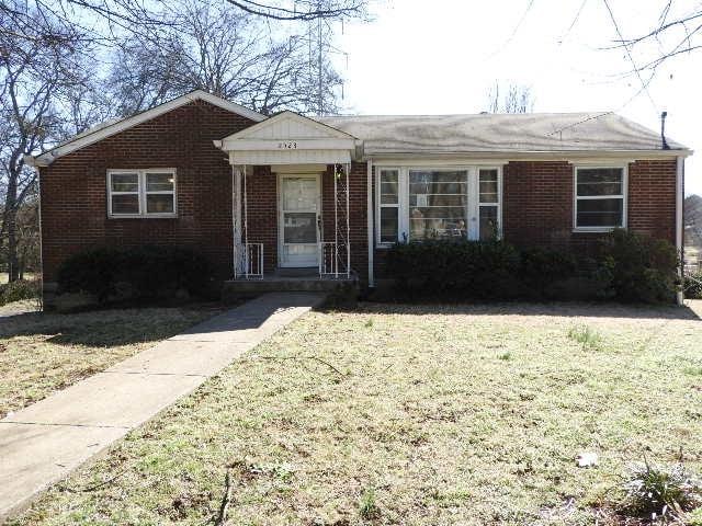 ranch-style house featuring a front yard and brick siding