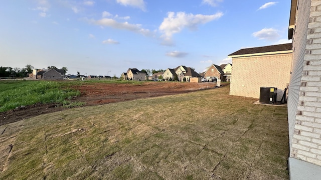 view of yard with a residential view and central AC unit