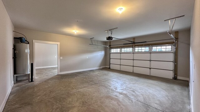 garage featuring water heater, baseboards, and a garage door opener