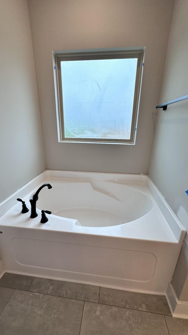 bathroom featuring tile patterned flooring and a bath