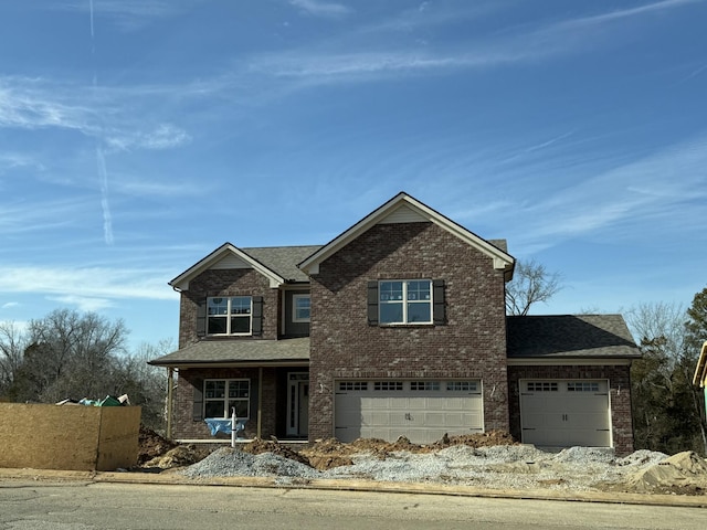 view of front of home featuring a shingled roof, fence, and brick siding