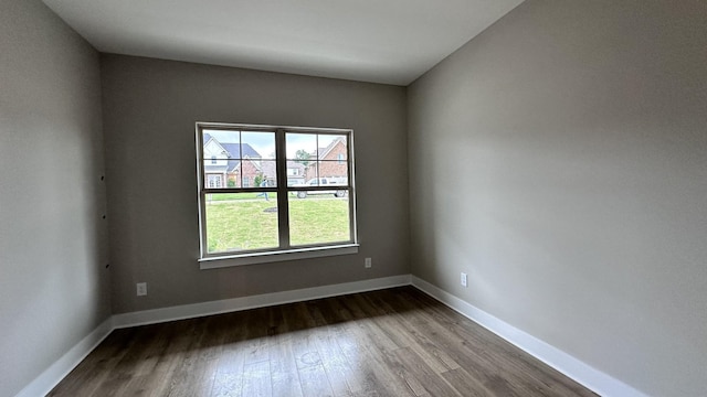 empty room with baseboards and wood finished floors