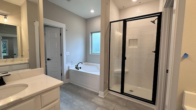 full bathroom featuring a stall shower, a garden tub, vanity, and baseboards