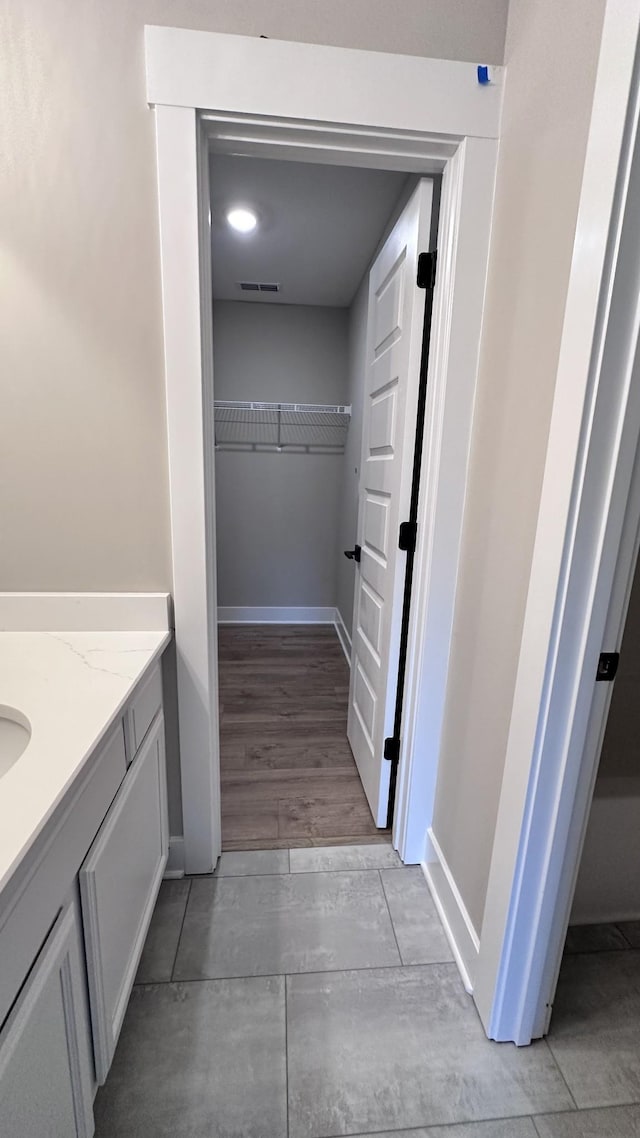 bathroom featuring baseboards, visible vents, and vanity