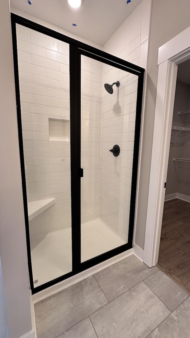 full bath with a shower stall and baseboards