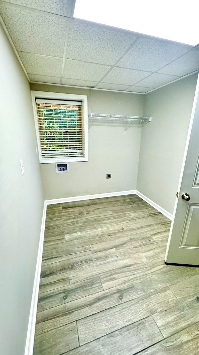 clothes washing area featuring hookup for a washing machine, laundry area, baseboards, and wood finished floors