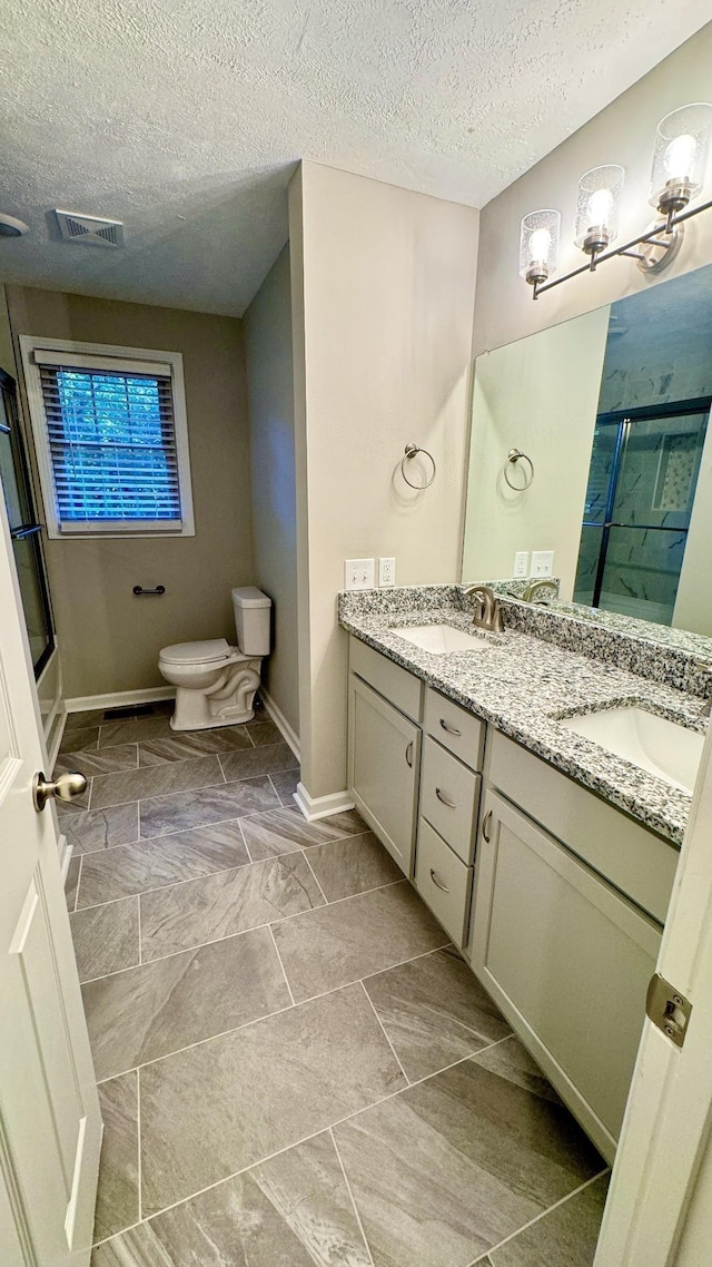 bathroom featuring visible vents, a sink, a shower stall, and toilet