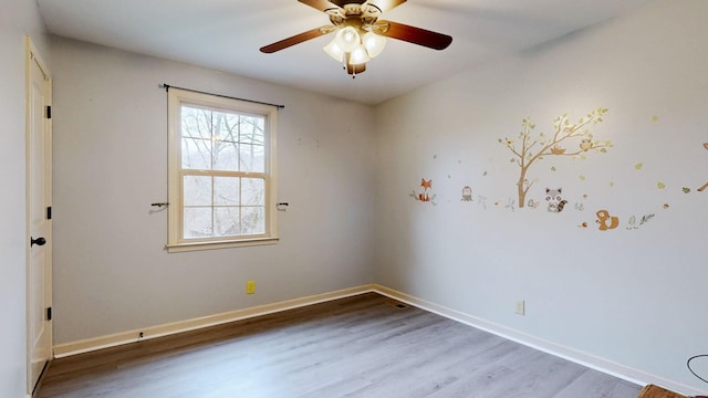 spare room with a ceiling fan, baseboards, and wood finished floors