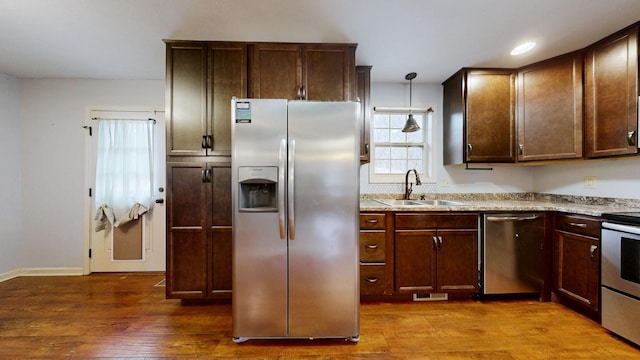 kitchen with dark brown cabinetry, visible vents, dark wood-style flooring, stainless steel appliances, and a sink