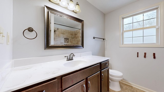 bathroom featuring toilet, vanity, and baseboards