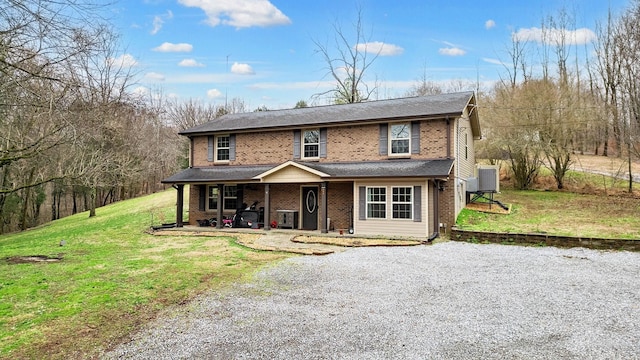 traditional-style home with a front yard, brick siding, and driveway