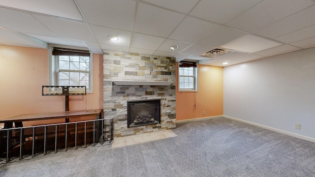 living area with visible vents, baseboards, a drop ceiling, carpet flooring, and a fireplace