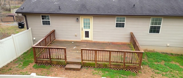 back of property featuring fence, a deck, and roof with shingles