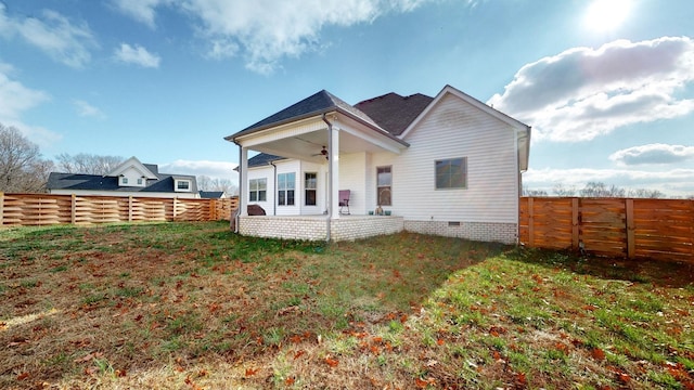 back of house featuring ceiling fan, a yard, crawl space, and a fenced backyard