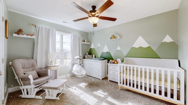 carpeted bedroom featuring a nursery area, visible vents, ceiling fan, and baseboards