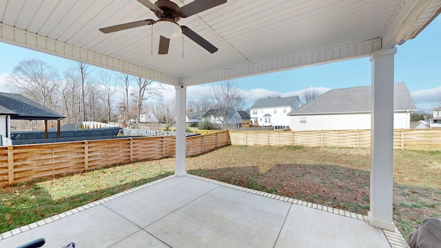 view of patio with a residential view, a fenced backyard, and a ceiling fan