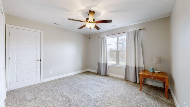 unfurnished room with light carpet, ceiling fan, visible vents, and baseboards