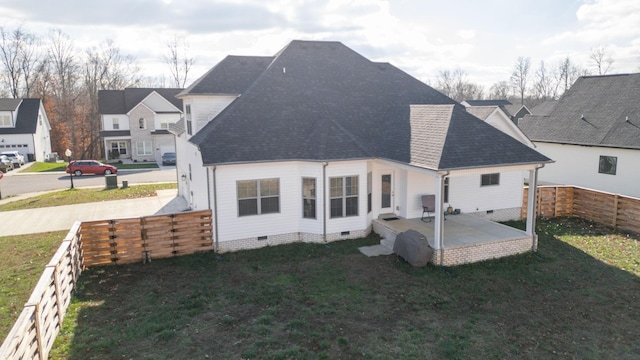 back of house with a lawn, a patio, a fenced backyard, roof with shingles, and crawl space