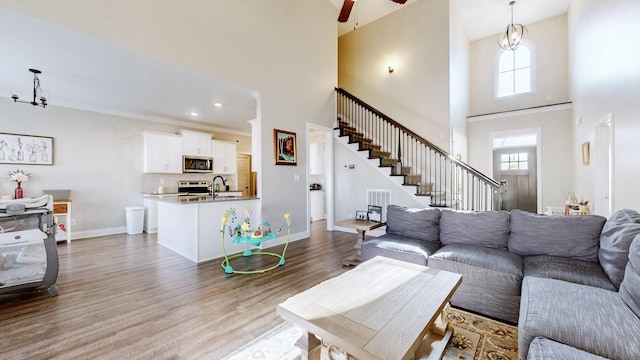 living room featuring a wealth of natural light, stairs, baseboards, and wood finished floors