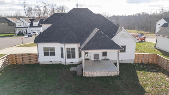 back of house featuring roof with shingles, a patio, a lawn, crawl space, and fence