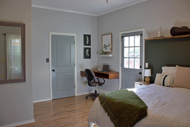 bedroom with crown molding, baseboards, and wood finished floors