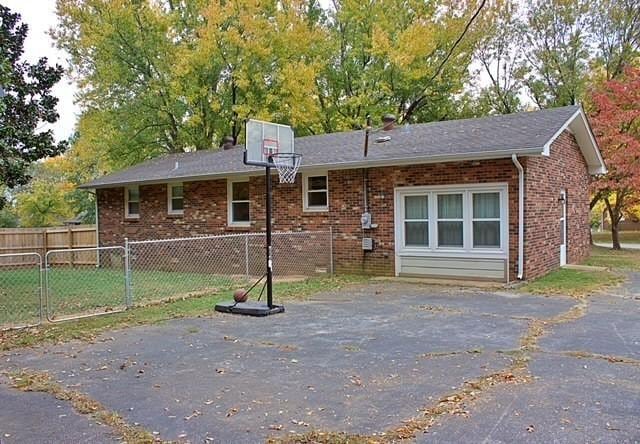 view of front facade featuring brick siding and fence