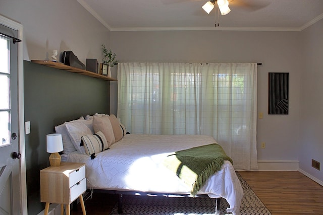 bedroom featuring baseboards, ornamental molding, ceiling fan, and wood finished floors