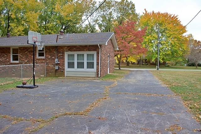 exterior space with a yard, fence, and brick siding