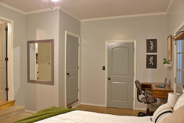 bedroom featuring a textured ceiling, ornamental molding, and wood finished floors