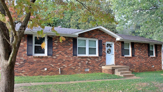 ranch-style house with a front yard, brick siding, and roof with shingles