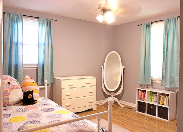 bedroom featuring ceiling fan, baseboards, and wood finished floors