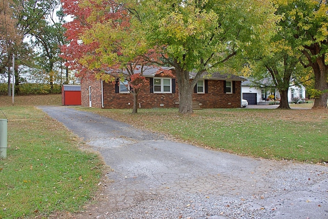 view of front of home featuring aphalt driveway, crawl space, an attached garage, a front yard, and brick siding