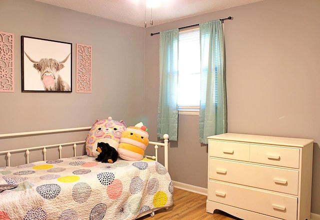 bedroom featuring light wood-style flooring and baseboards