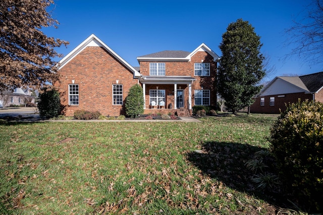 traditional-style house featuring brick siding and a front yard