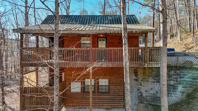 view of home's exterior with metal roof and log veneer siding