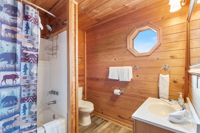 bathroom featuring shower / bath combination with curtain, toilet, vanity, wooden walls, and wood finished floors