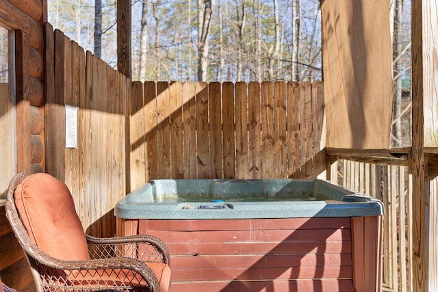 exterior space with a hot tub and fence