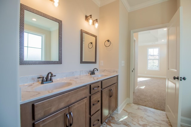 bathroom with marble finish floor, double vanity, a sink, and crown molding