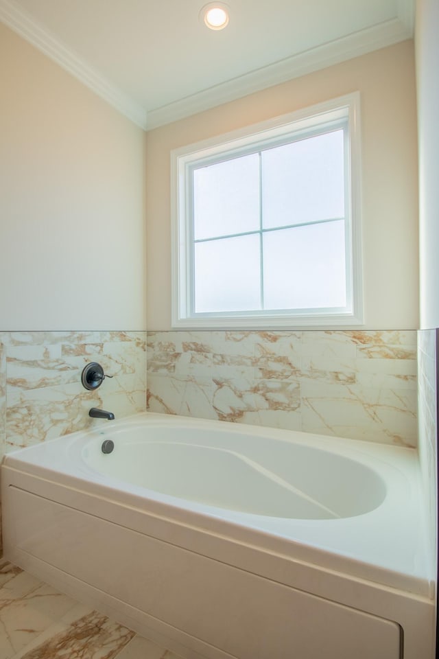 bathroom featuring a garden tub, marble finish floor, and crown molding