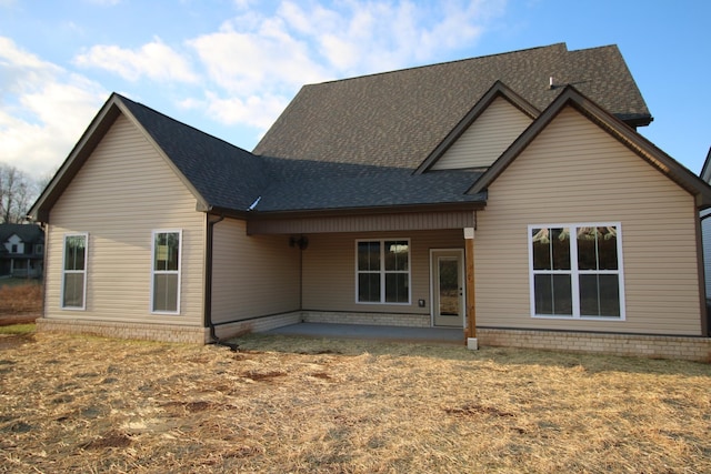 rear view of property featuring a patio area and a shingled roof