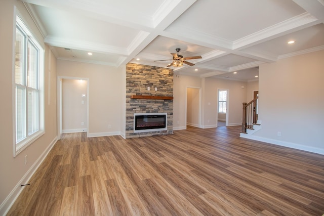 unfurnished living room featuring a fireplace, stairway, wood finished floors, coffered ceiling, and baseboards