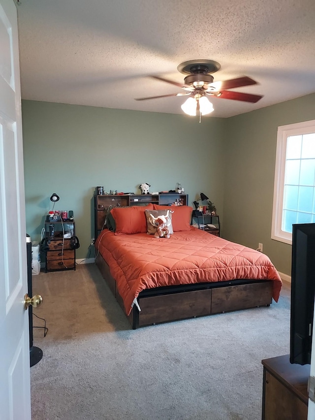 bedroom with baseboards, a textured ceiling, a ceiling fan, and carpet flooring