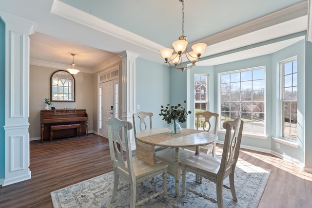 dining room with dark wood-style flooring, baseboards, an inviting chandelier, decorative columns, and crown molding