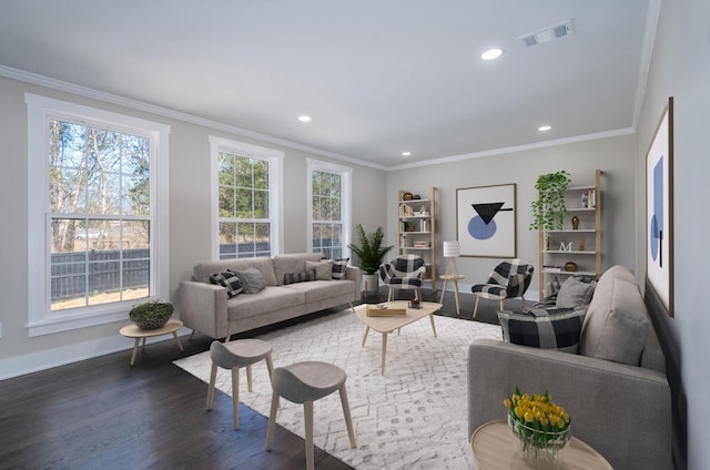 living area with dark wood-type flooring, a wealth of natural light, visible vents, and crown molding