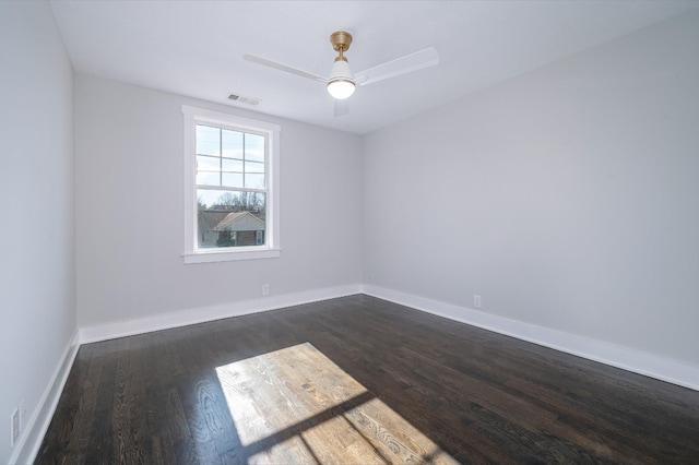 unfurnished room featuring dark wood-type flooring, a ceiling fan, visible vents, and baseboards